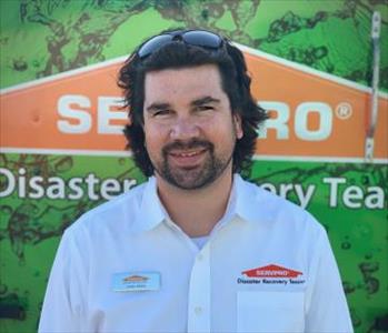 White male.  Smiling.  Wearing a white shirt with a SERVPRO logo over his shirt pocket.
