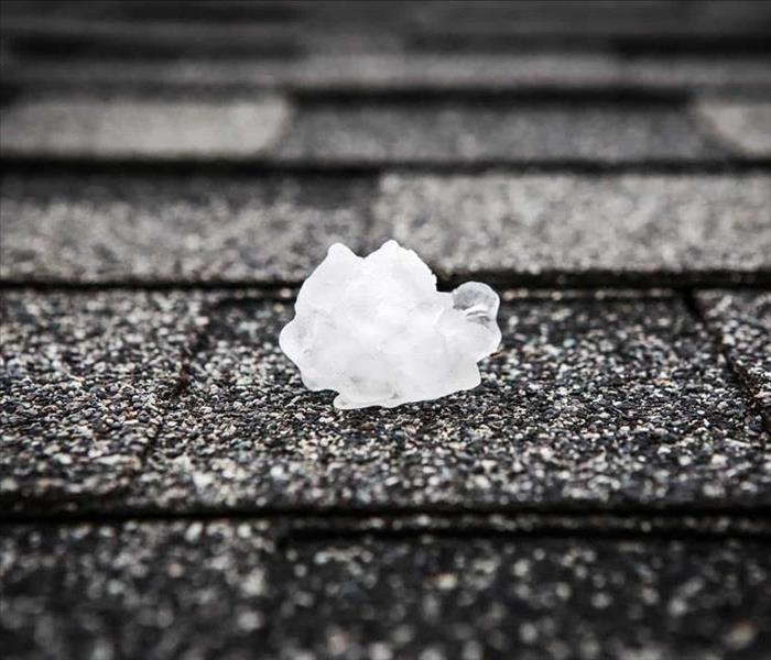 hail ice on a black roof shingle
